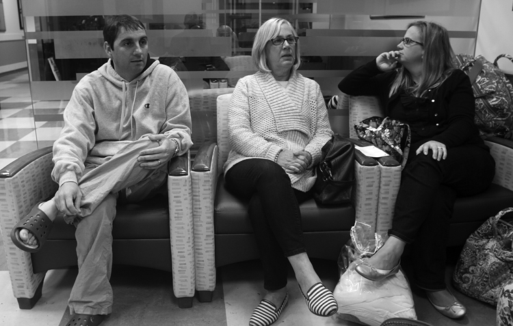 Chris Parani, left, sits with his mother-in-law Millie Fraley and sister-in-law Kim Pope, in a family waiting area, while Aimee is in surgery.