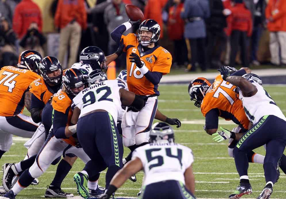 Denver quarterback Peyton Manning passes while under pressure during the fourth quarter of Super Bowl XLVIII, Sunday, February 2, 2014, at MetLife Stadium in East Rutherford, NJ.